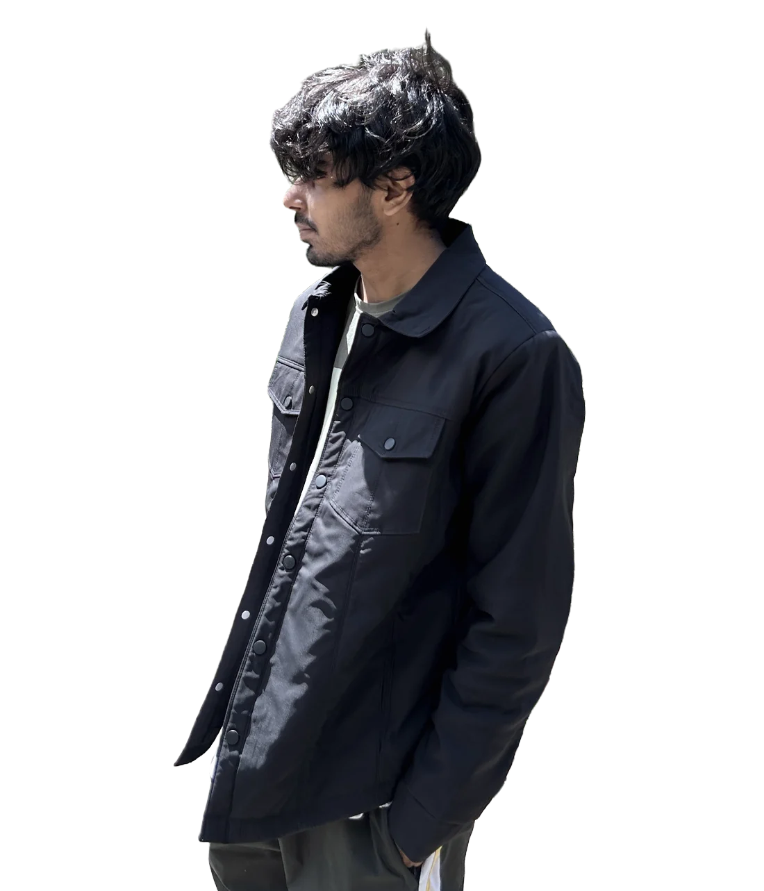 Yash Dhiman in a black jacket on a footbridge in Kasol, looking out over the valley